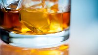 Close-up view of alcoholic beverage on ice in a glass on isolated background.