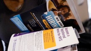 An attendee holds pamphlets at the Albany Job Fair in Latham, New York, US, on Wednesday, Oct. 2, 2024. 