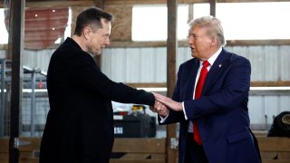 Elon Musk (L) shakes hands with Republican presidential nominee, former President Donald Trump back stage during a campaign rally at the Butler Farm Show grounds on October 05, 2024 in Butler, Pennsylvania.