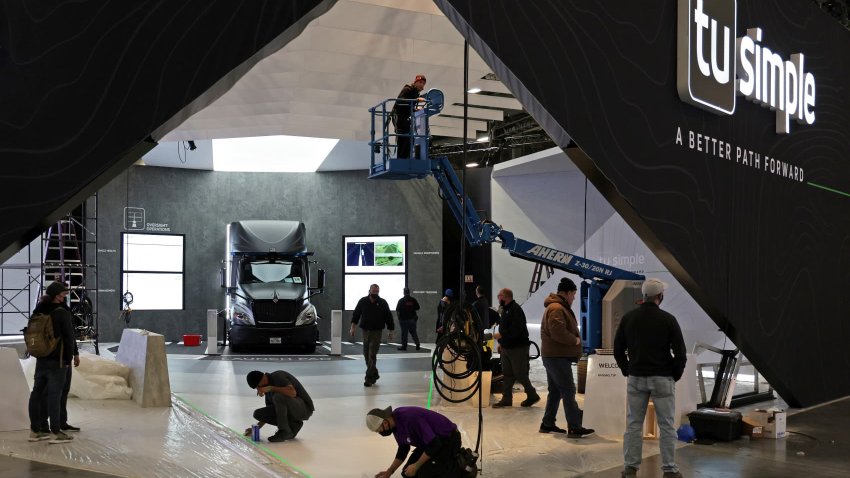 Workers setting up the TuSimple booth for CES 2022 at the Las Vegas Convention Center on Jan. 3, 2022.