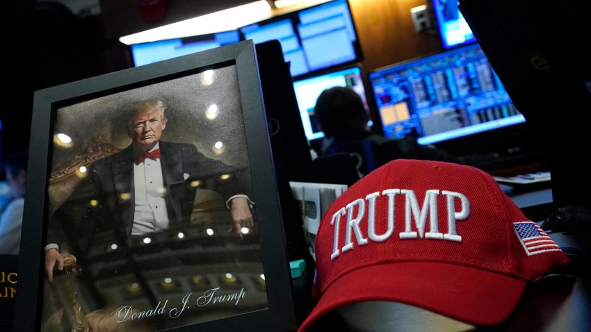 President elect Donald Trump items on display as traders and financial professionals work on the floor of the New York Stock Exchange (NYSE) during the first session of the new year on January 2, 2025, in New York City. (Photo by TIMOTHY A. CLARY / AFP) (Photo by TIMOTHY A. CLARY/AFP via Getty Images)