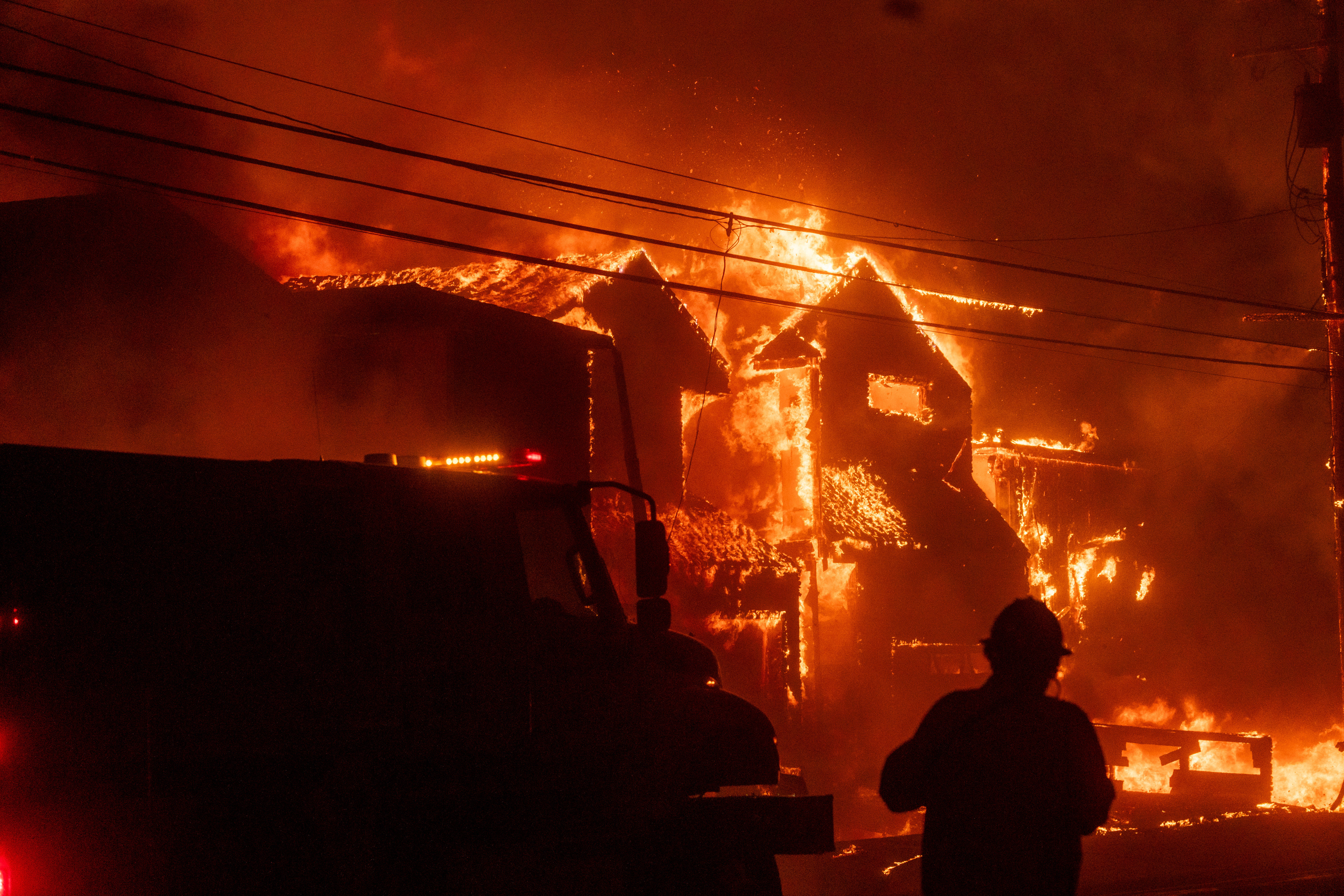 A firefighter in front of a burning structure during the Palisades Fire in the Pacific Palisades neighborhood of Los Angeles, California, US, on Tuesday, Jan. 7, 2025. Photographer: Kyle Grillot/Bloomberg via Getty Images