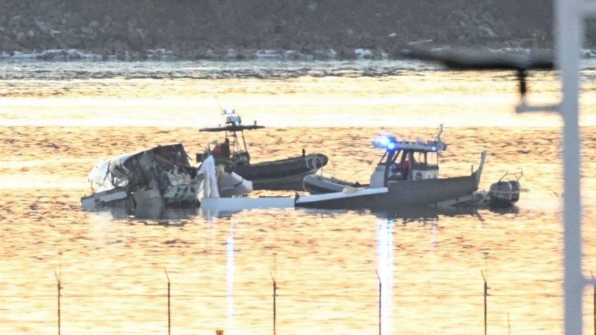 Part of the wreckage is seen as rescue boats search the waters of the Potomac River after a plane on approach to Reagan National Airport crashed into the river outside Washington, DC, January 30, 2025. A regional jet from Kansas crashed into Washington’s Potomac River after colliding mid-air with a military helicopter near Reagan National Airport, officials said January 29, prompting a major emergency response and grounding all flights. (Photo by ANDREW CABALLERO-REYNOLDS / AFP) (Photo by ANDREW CABALLERO-REYNOLDS/AFP via Getty Images)