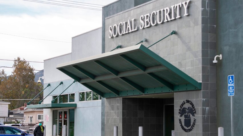 A person wearing a facemask stands outside a US Social Security Administration building, November 5, 2020, in Burbank, California.