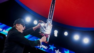 Elon Musk holds up a chainsaw onstage during the Conservative Political Action Conference (CPAC) in National Harbor, Maryland, U.S., February 20, 2025. 