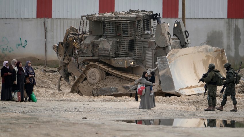 Israeli soldiers check the identification cards of Palestinians while they evacuate their homes in the West Bank refugee camp of Nur Shams, near Tulkarem, while the Israeli military operation continues in the area on Tuesday, Feb. 11, 2025.