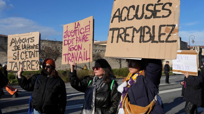 FILE - Activists hold posters