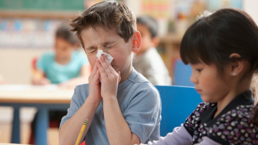 Boy blowing his nose at school.