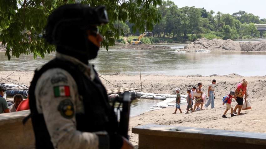 A military officer monitors the flow of people as the U.S.-Mexico border closes