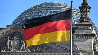 A German flag flutters in the wind in front of the cupola of the Reichstag building that houses the Bundestag (lower house of German parliament) on February 24, 2025 in Berlin, one day after general elections.