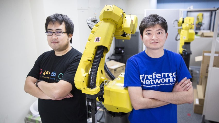 Toru Nishikawa (right), co-founder and chief executive officer of Preferred Networks, and Daisuke Okanohara, co-founder and chief executive researcher, with a Fanuc Corp. robotic arm at their company’s headquarters in Tokyo, Japan, March 16, 2018.