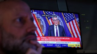 A trader works, as a screen broadcasts a news conference by U.S. Federal Reserve Chair Jerome Powell following the Fed rate announcement, on the floor of the New York Stock Exchange in New York City, U.S., March 19, 2025.
