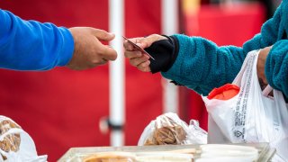 A shopper pays with a credit card at the farmer’s market in San Francisco, California, US, on Thursday, March 27, 2025.