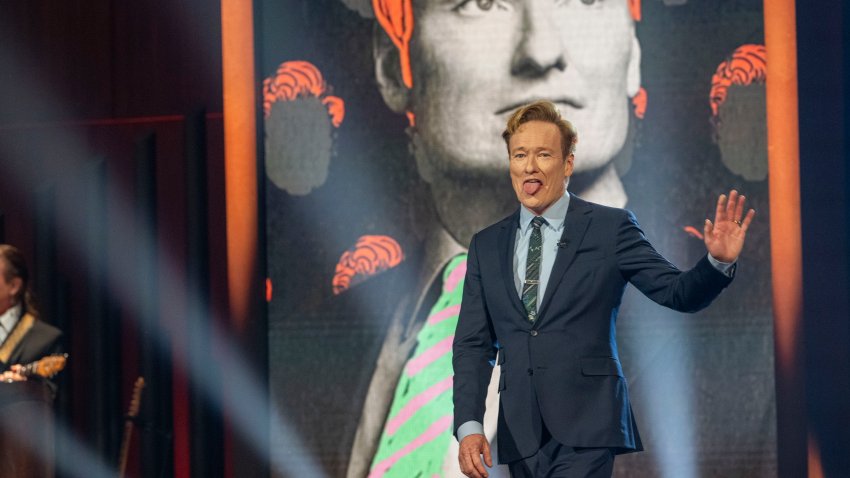 Comedian Conan O'Brien walks out on stage