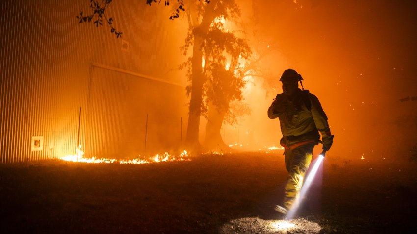 Bloomberg Best of the Year 2019: A firefighter uses a flashlight to search the perimeter of a building at the Soda Rock Vineyards during the Kincade fire in Healdsburg, California, U.S., on Sunday, Oct. 27, 2019.