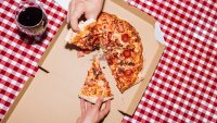 Top view of friends eating pepperoni pizza and drinking wine
