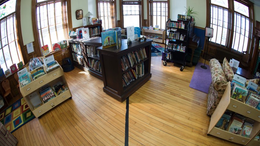 This Feb. 28, 2017, file photo shows black tape marking the U.S./Canada border inside the Haskell Free Library and Opera House in Stanstead, Quebec, (right), and Derby Line, Vermont, (left). The neoclassical building straddles the international border and was built that way on purpose.