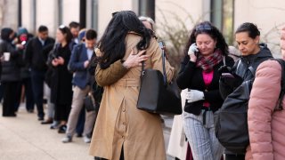 Employees of the Department of Health and Human Services (HHS) hug each other as they queue outside the Mary E. Switzer Memorial Building, after it was reported that the Trump administration fired staff at the Centers for Disease Control and Prevention and at the Food and Drug Administration, as it embarked on its plan to cut 10,000 jobs at HHS, in Washington, D.C., U.S., April 1, 2025. 