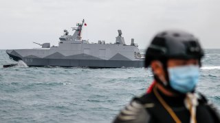 A Taiwanese military corvette sails as a Navy soldier stands guard on a vessel, during a Navy Drill for Preparedness Enhancement ahead of the Chinese New Year, amid escalating Chinese threats to the island, in Keelung, Taiwan, 7 Jan, 2022.