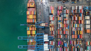 A container cargo ship at a port terminal in Thailand.