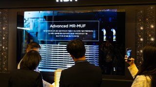 Visitors look at the display of SK Hynix Inc. 12-layer HBM3E memory chips at the Semiconductor Exhibition (SEDEX) in Seoul, South Korea, on Wednesday, Oct. 23, 2024.