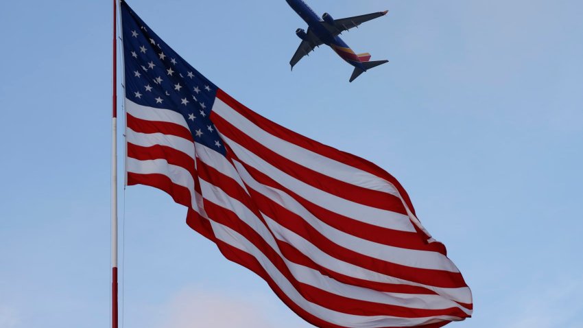 A Southwest Airlines Boeing 737 departs from San Diego International Airport with an American flag in the foreground on April 20, 2025 in San Diego, California, U.S.