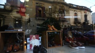 A photograph of the late Pope Francis sits in the window of the Muglia shoe store alongside the model of shoes that Jorge Bergoglio used in the Flores neighborhood where he grew up in Buenos Aires, Argentina, Thursday, April 24, 2025.