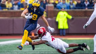 ANN ARBOR, MICHIGAN – OCTOBER 14: Colston Loveland #18 of the Michigan Wolverines runs for extra yardage against Aaron Casey #44 of the Indiana Hoosiers during the first half of a college football game at Michigan Stadium on October 14, 2023 in Ann Arbor, Michigan. (Photo by Aaron J. Thornton/Getty Images)