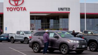 A customer looks at a used vehicle for sale at a Toyota dealership