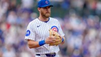 Gage Workman of the Cubs stands with his throwing hand on his glove. He's wearing the Cubs' white jersey with blue pinstripes.