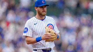 Gage Workman of the Cubs stands with his throwing hand on his glove. He's wearing the Cubs' white jersey with blue pinstripes.