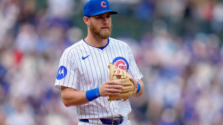 Gage Workman of the Cubs stands with his throwing hand on his glove. He's wearing the Cubs' white jersey with blue pinstripes.