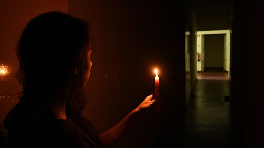 A woman is seen holding a candle for light as Spain, Portugal and other parts of Europe are hit with widespread power blackouts in Lisbon, Portugal, on April 28, 2025.