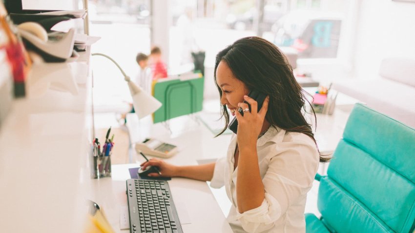 Woman talks on the phone at work.