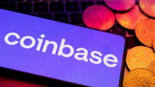 A smartphone with the Coinbase logo and representation of cryptocurrencies are placed on a keyboard in this photo taken June 8, 2023.