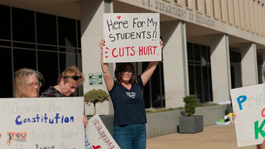 Sarah Jo Marcotte, an educator from Vermont, holds a sign that reads “Here for my students!! Cuts Hurt.” outside of the U.S. Department of Education on March 20, 2025 in Washington, DC.