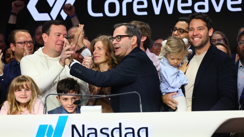 CoreWeave founders Brian Venturo, at left in sweatshirt, and Mike Intrator slap five after ringing the opening bell at Nasdaq headquarters in New York on March 28, 2025.