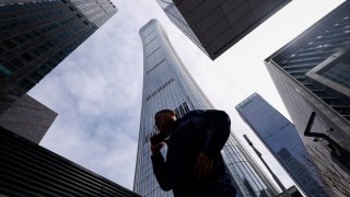 A man walks past buildings at Central Business District (CBD) in Beijing, China April 8, 2025.