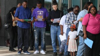 People line up as they wait for the Mega JobNewsUSA South Florida Job Fair to open at the Amerant Bank Arena on April 30, 2025 in Sunrise, Florida.