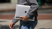 A customer carries an Apple MacBook Pro laptop outside an Apple store in Walnut Creek, California, US, on Wednesday, April 30, 2025.