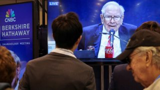 People watch as Berkshire Hathaway chairman Warren Buffett is seen on a screen speaking at the Berkshire Hathaway Inc annual shareholders’ meeting, in Omaha, Nebraska, U.S., May 3, 2025.
