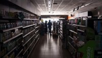 Employees stand inside a supermarket without lights in Burgos on April 28, 2025, during a massive power cut affecting the entire Iberian peninsula and the south of France.