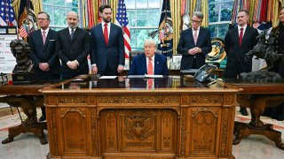 US President Donald Trump makes a trade announcement as US Secretary of Commerce Howard Lutnick (2L), US Vice President JD Vance (3L), British ambassador to the United States Peter Mandelson (3R),  US Trade Representative Jamieson Greer (3R) and US Secretary of Agriculture Brooke Rollins (R) look on in the Oval Office of the White House in Washington, DC, on May 8, 2025.