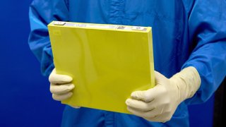 An employee holds a full-size prototype LMR battery cell at the General Motors Wallace Battery Cell Innovation Center. GM has prototyped approximately 300 full-size LMR cells as it worked with LG Energy Solution to crack the code on the chemistry.