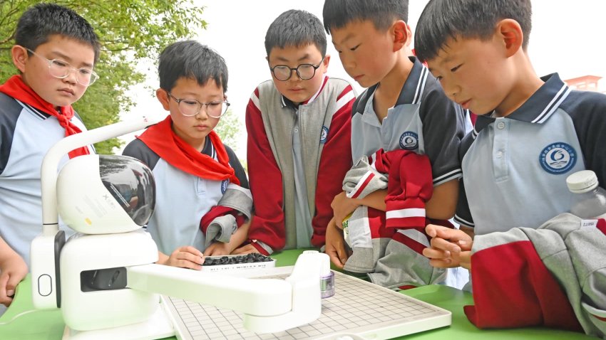 A student is playing chess with an intelligent robot in Xuzhou City, Jiangsu Province, China on May 13, 2025.
