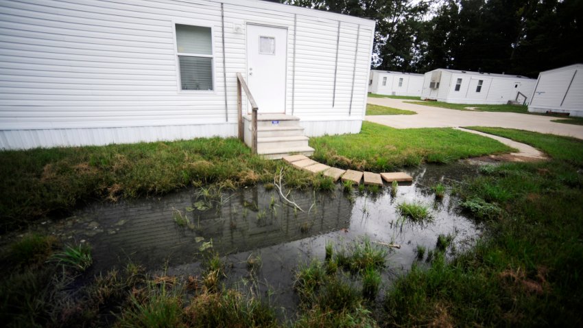 FILE – Fetid water pools outside a mobile home in a small mobile home park in rural Hayneville, Ala., Lowndes County, Aug. 1, 2022.