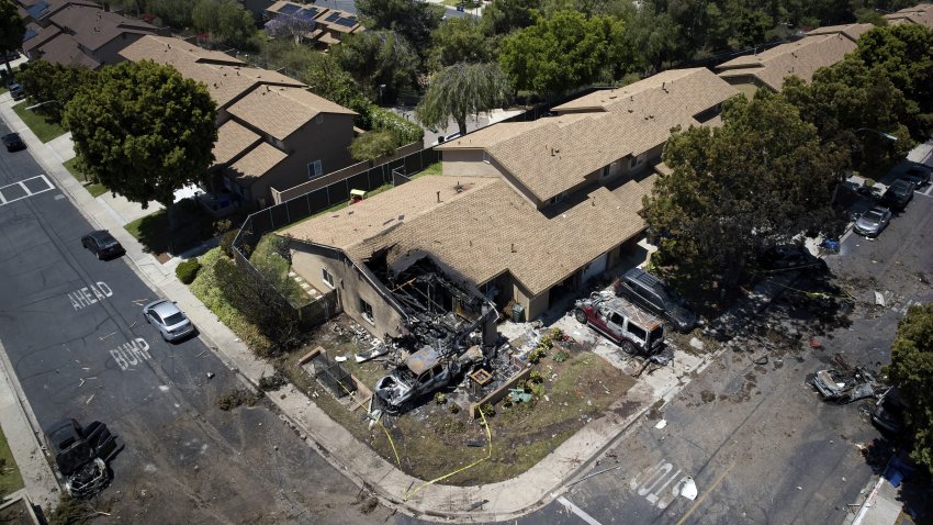 Debris covers the ground after a small plane crashed into a San Diego neighborhood, setting homes and cars on fire and forcing evacuations early Thursday, May 22, 2025.