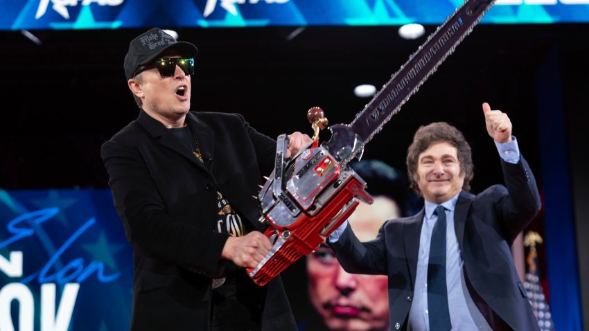 Elon Musk holds up a chainsaw he received from Argentina's President Javier Milei