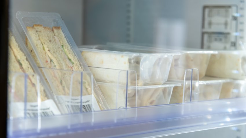 Close-up view of various prepared food lying on fridge shelf in micro market (small unmanned vending store). Soft focus. Food technology theme.