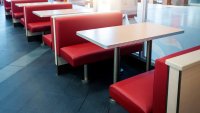Empty fastfood restaurant interior with red chairs and table in a row